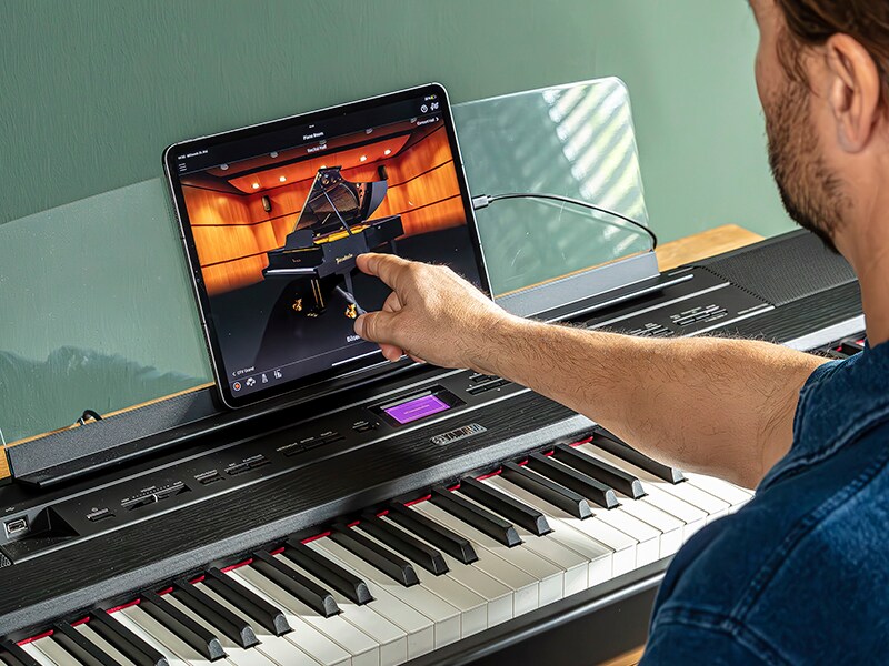 The Yamaha “Smart Pianist” app icon, together with a tablet placed on the music stand of the　P-525